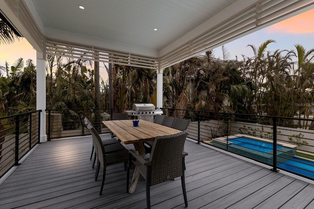 deck at dusk featuring area for grilling