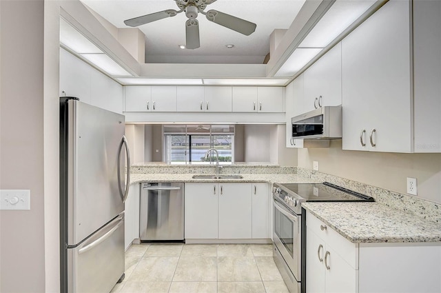 kitchen featuring ceiling fan, sink, light stone countertops, stainless steel appliances, and white cabinets