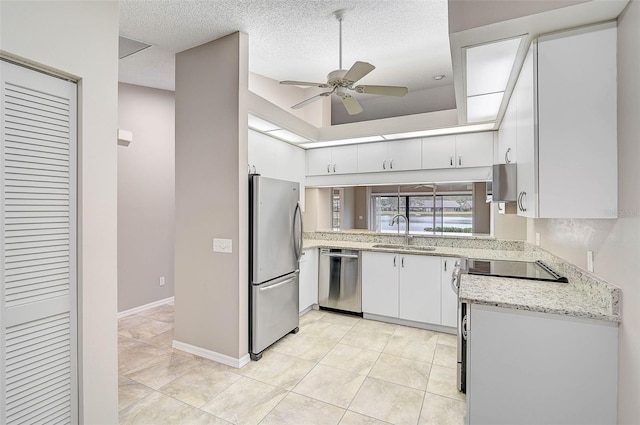 kitchen featuring ceiling fan, stainless steel appliances, a textured ceiling, white cabinets, and sink