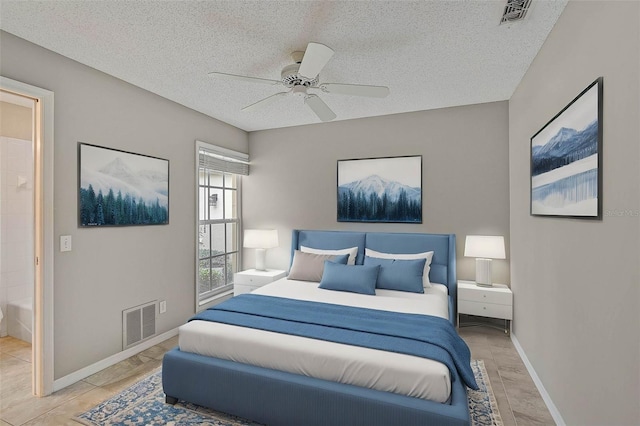 bedroom featuring ceiling fan, light tile patterned flooring, connected bathroom, and a textured ceiling