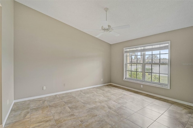 empty room with ceiling fan, a textured ceiling, and light tile patterned floors