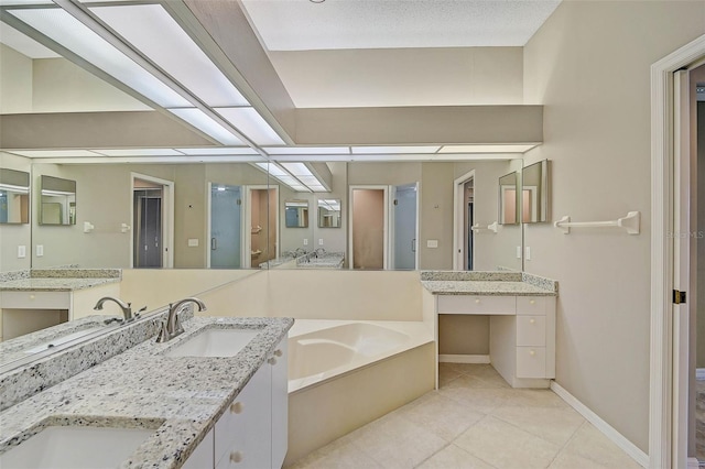 bathroom featuring a tub to relax in, vanity, and tile patterned flooring