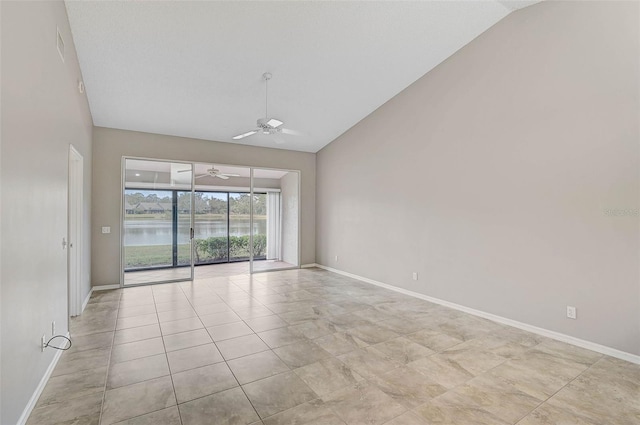 unfurnished room with vaulted ceiling, ceiling fan, and a water view