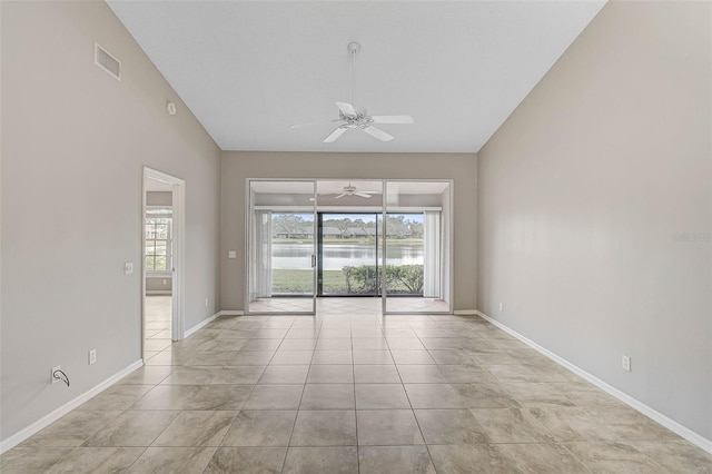 tiled spare room with ceiling fan and a water view