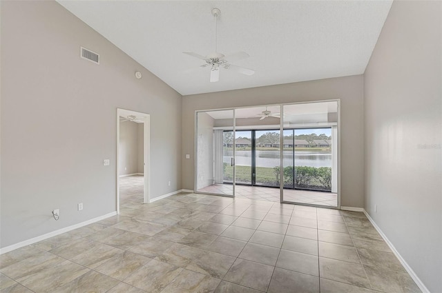 spare room with a water view, ceiling fan, and vaulted ceiling