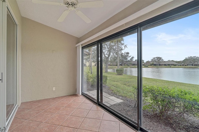 unfurnished sunroom with ceiling fan and a water view