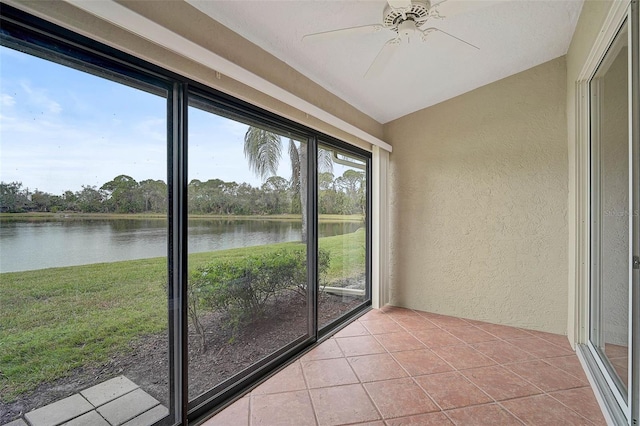 unfurnished sunroom with a water view, vaulted ceiling, and ceiling fan