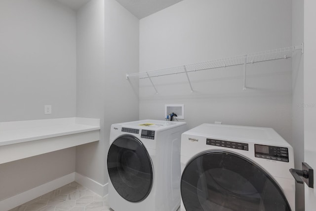 laundry room with washing machine and dryer and light tile patterned flooring