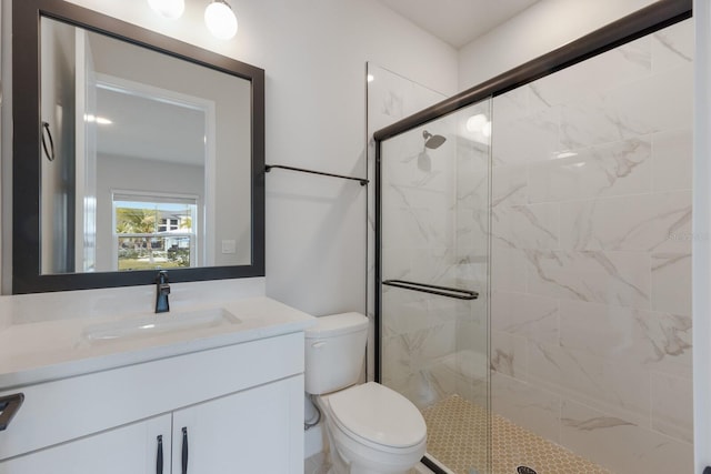 bathroom featuring toilet, an enclosed shower, and vanity