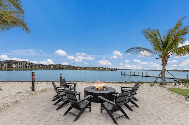 view of patio with a fire pit and a water view