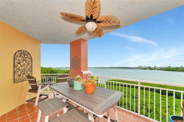 balcony featuring a water view and ceiling fan