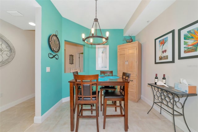 tiled dining space featuring a notable chandelier