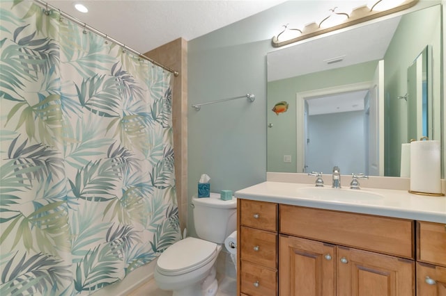 bathroom with vanity, toilet, and a textured ceiling