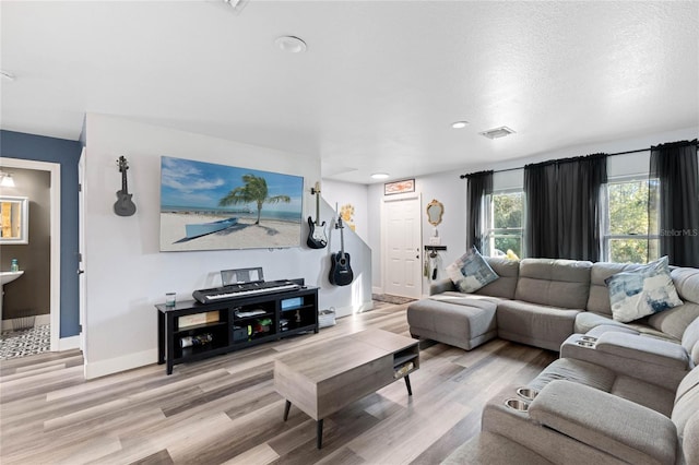 living room featuring a textured ceiling and light hardwood / wood-style flooring