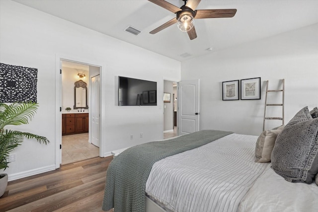 bedroom with hardwood / wood-style floors, ceiling fan, and connected bathroom