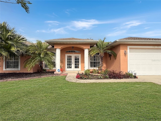 view of front of house featuring a garage, a front yard, and french doors