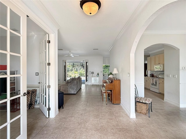 hallway featuring light tile patterned floors, ornamental molding, and french doors