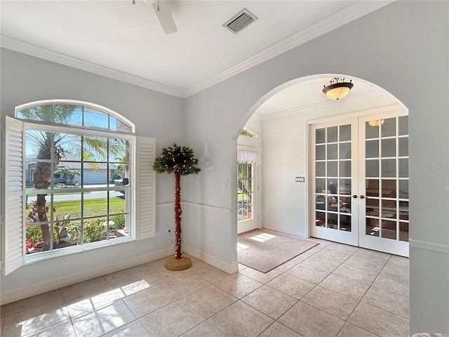 entryway with ceiling fan, french doors, light tile patterned floors, and crown molding