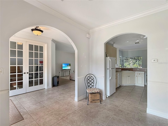 hallway with sink, light tile patterned floors, and ornamental molding