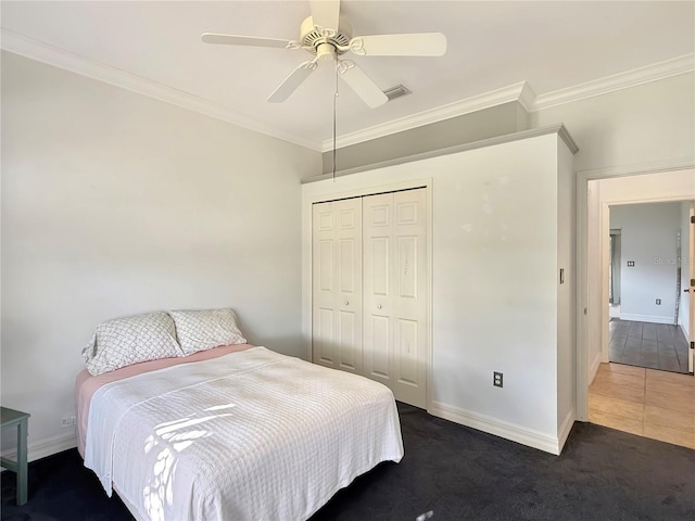 bedroom with ceiling fan, a closet, dark carpet, and ornamental molding