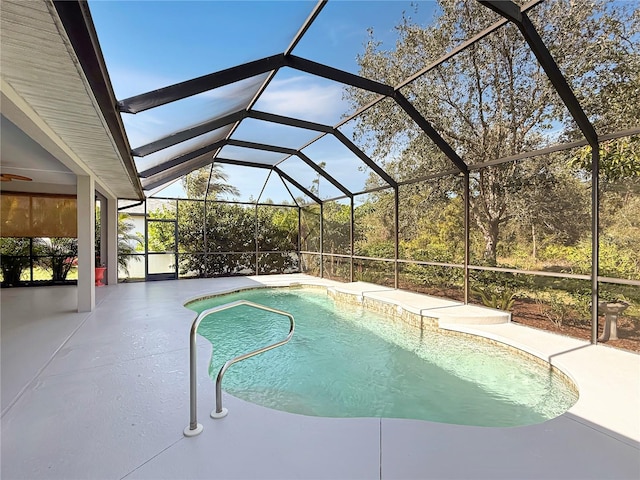 view of swimming pool with glass enclosure and a patio area