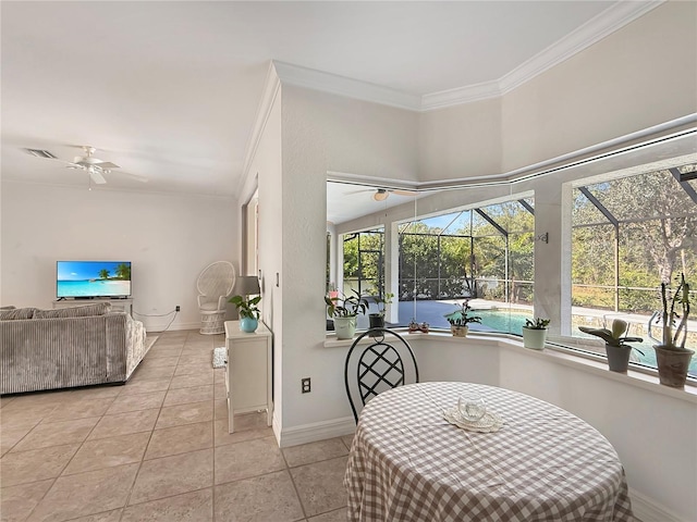 tiled dining area with ceiling fan and ornamental molding