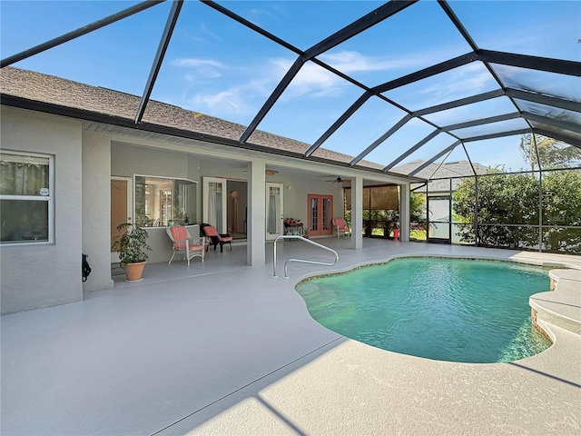 view of pool featuring glass enclosure, ceiling fan, a patio area, and french doors