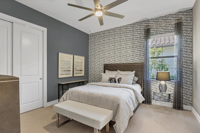 carpeted bedroom with ceiling fan, a closet, and lofted ceiling