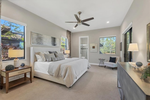 carpeted bedroom with ensuite bathroom and ceiling fan