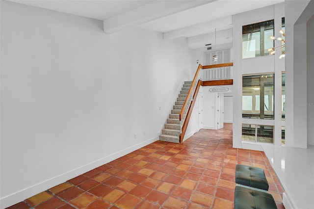 unfurnished living room featuring beam ceiling, a towering ceiling, stairway, light tile patterned flooring, and baseboards