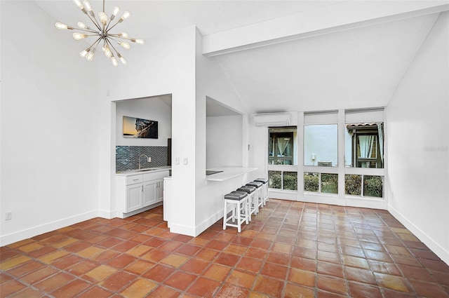 unfurnished living room featuring vaulted ceiling with beams, a sink, baseboards, and an inviting chandelier