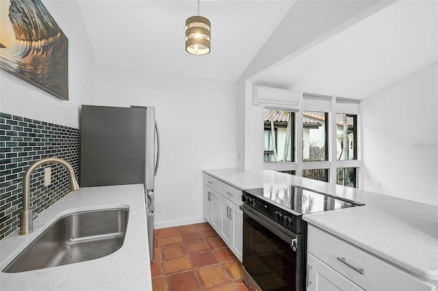 kitchen with white cabinetry, electric range, sink, dark tile patterned floors, and vaulted ceiling