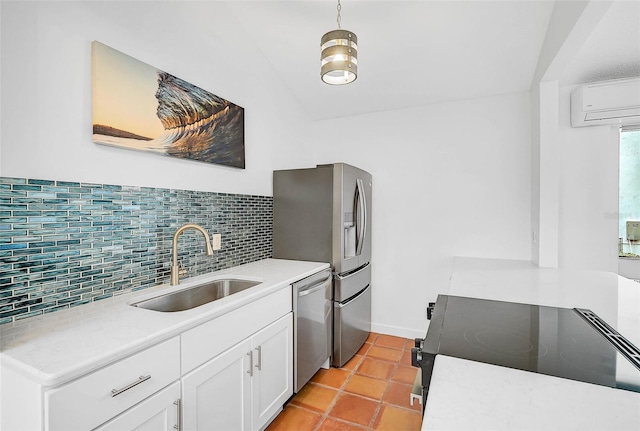 kitchen featuring stainless steel appliances, a wall mounted AC, sink, pendant lighting, and white cabinets