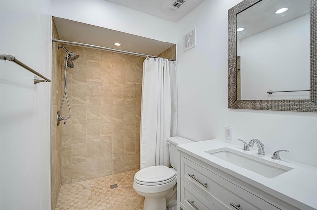 full bathroom featuring toilet, visible vents, a tile shower, and vanity