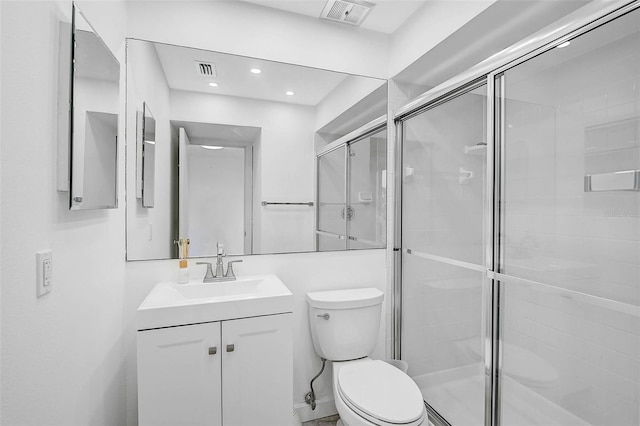 bathroom with vanity, toilet, and an enclosed shower