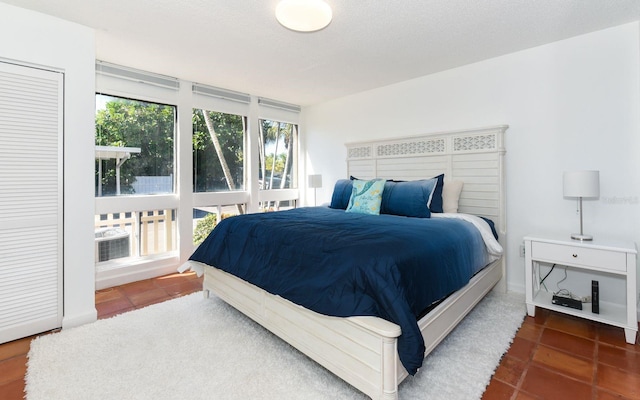 bedroom with a textured ceiling and dark tile patterned flooring