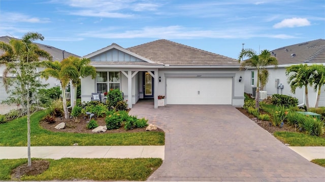 view of front of property featuring a garage and central AC