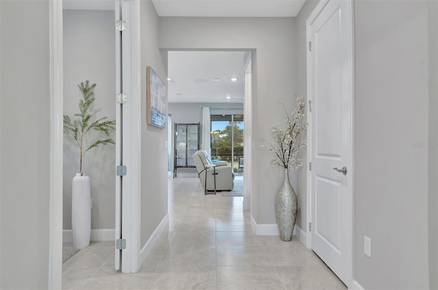 hall featuring light tile patterned floors