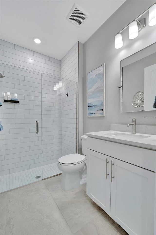 bathroom featuring vanity, toilet, and a shower with door