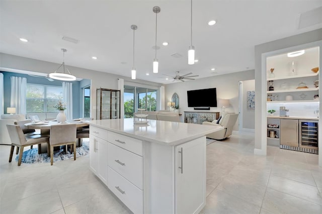 kitchen featuring hanging light fixtures, ceiling fan, white cabinetry, light tile patterned floors, and a kitchen island