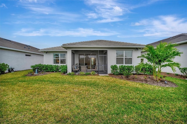 rear view of property with a sunroom and a lawn