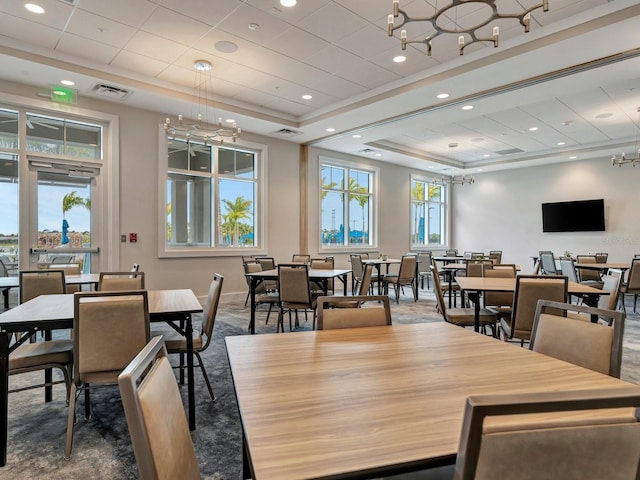 dining area with carpet and a tray ceiling