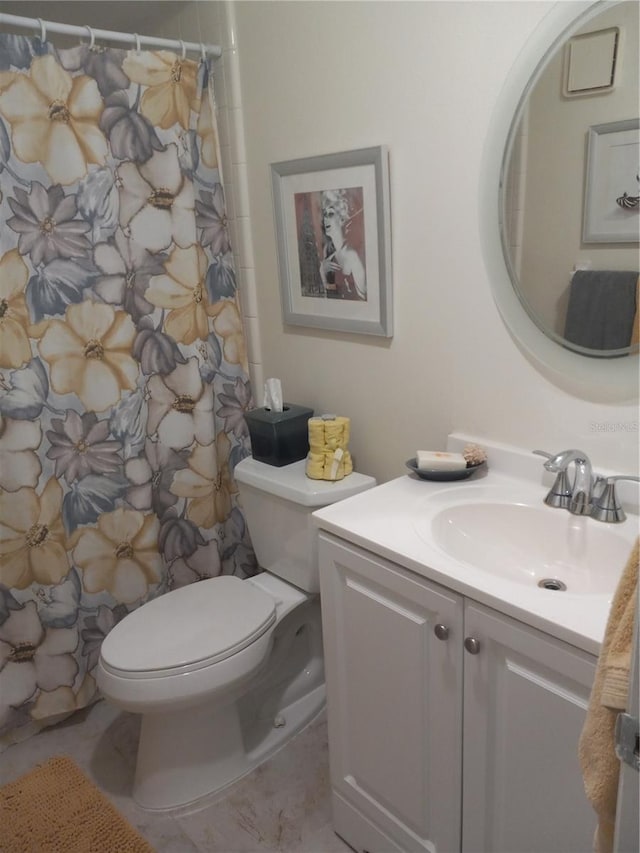 bathroom with toilet, walk in shower, and vanity