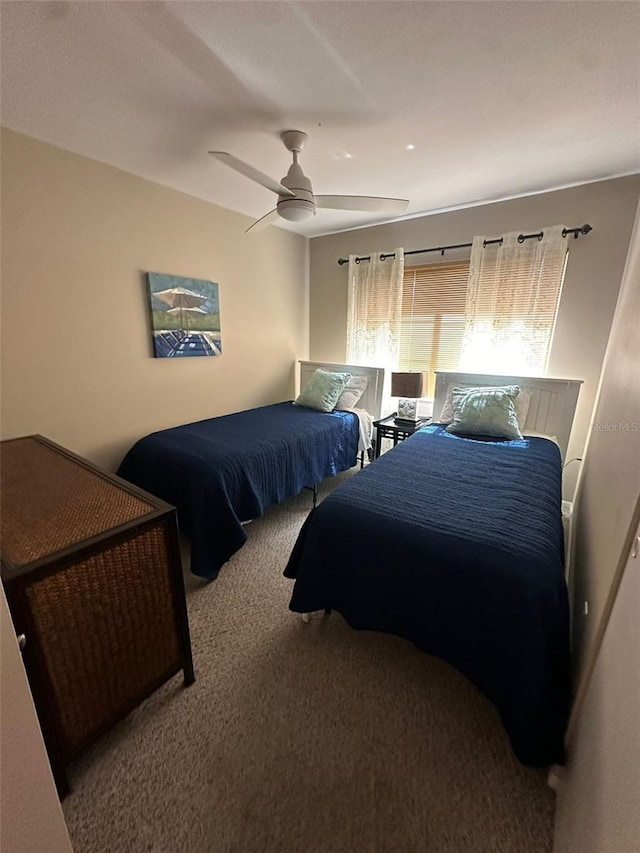 bedroom featuring ceiling fan and carpet