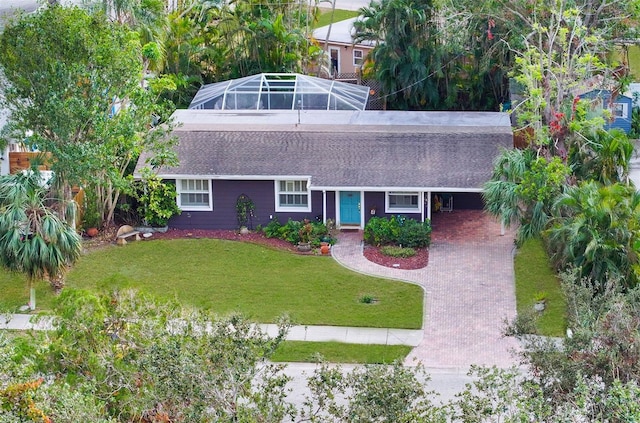 view of front of property with a carport, a lanai, and a front yard