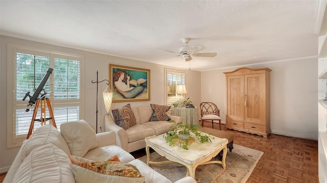 living room featuring ceiling fan, dark parquet floors, crown molding, and a textured ceiling