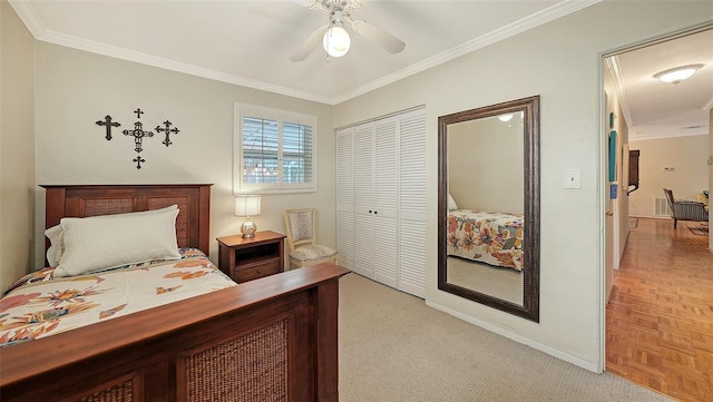 carpeted bedroom with ceiling fan, ornamental molding, and a closet