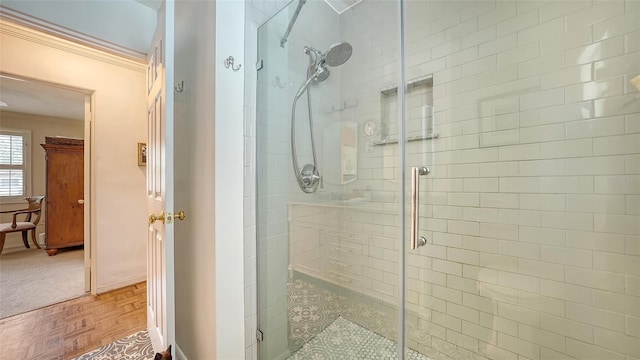 bathroom featuring crown molding, a shower with shower door, and parquet flooring