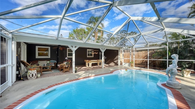 view of pool with a lanai, outdoor lounge area, ceiling fan, and a patio