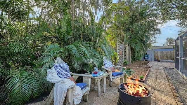 view of patio / terrace featuring a shed and a fire pit